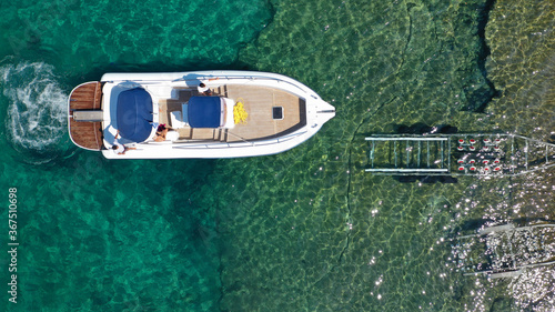 Aerial top view photo of inflatable speed boat on trailer being towed by truck from emerald exotic sea to land