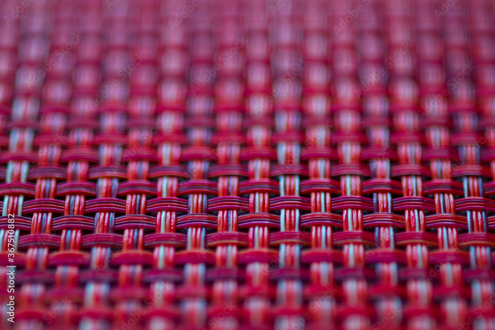 Fototapeta premium Vivid red basket weave mesh texture background with limited focus