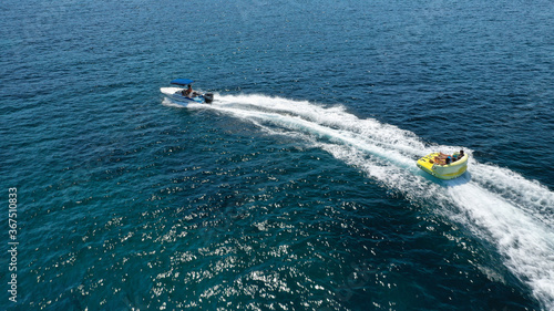 Aerial drone tracking photo of extreme power boat donut water-sports cruising in high speed in open ocean deep blue bay