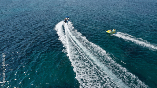 Aerial drone tracking photo of extreme power boat donut water-sports cruising in high speed in open ocean deep blue bay © aerial-drone