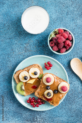 Fototapeta Naklejka Na Ścianę i Meble -  Funny breakfast toast for kids shaped as cute owl, dog. Food art sandwich for child. Isolated. Animal faces toasts with spreads, fruits