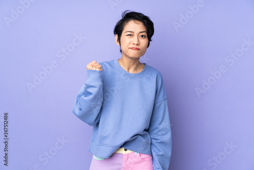 Young asian woman isolated on blue background 

