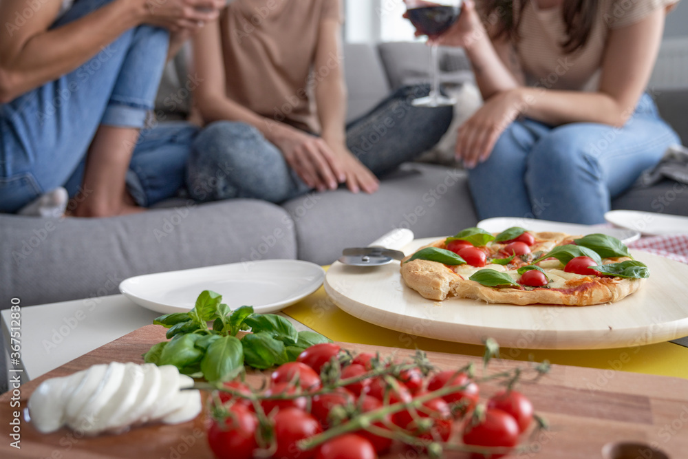 Detail of homemade pizza and wine in the background Detail of homemade pizza and wine in the background