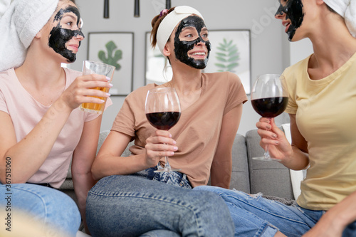Canvas Print Women with carbon facial mask drinking wine