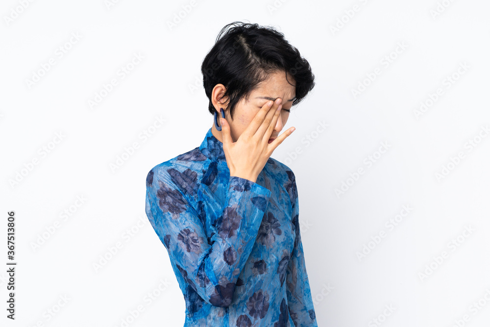 Young Vietnamese woman with short hair wearing a traditional dress over isolated white background with headache Young Vietnamese woman with short hair wearing a traditional dress over isolated white background with headache