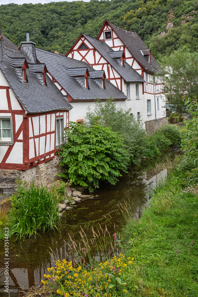 Rural scene with half-timbered houses beside a creek in a typical ancient German village
