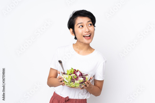 Young Vietnamese woman with short hair holding a salad over isolated background