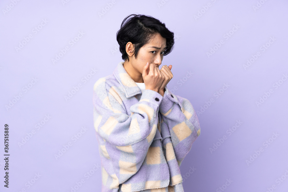 Young Vietnamese woman with short hair over isolated background nervous and scared putting hands to mouth Young Vietnamese woman with short hair over isolated background nervous and scared putting hands to mouth