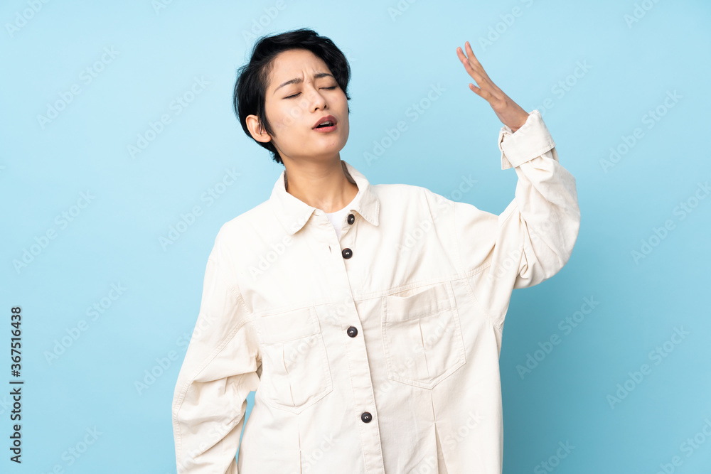 Young Vietnamese woman with short hair over isolated background with tired and sick expression Young Vietnamese woman with short hair over isolated background with tired and sick expression
