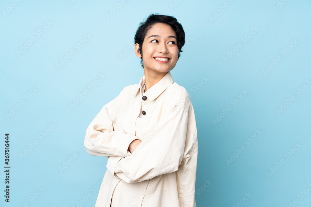 Young Vietnamese woman with short hair over isolated background with arms crossed and happy Young Vietnamese woman with short hair over isolated background with arms crossed and happy