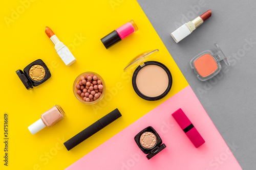 Lauout of multicolor cosmetics - powder concealer eye shadow lipstic. Top view