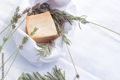 Soap bar ahd lavender flowers on white cloth background, homemade concept photo