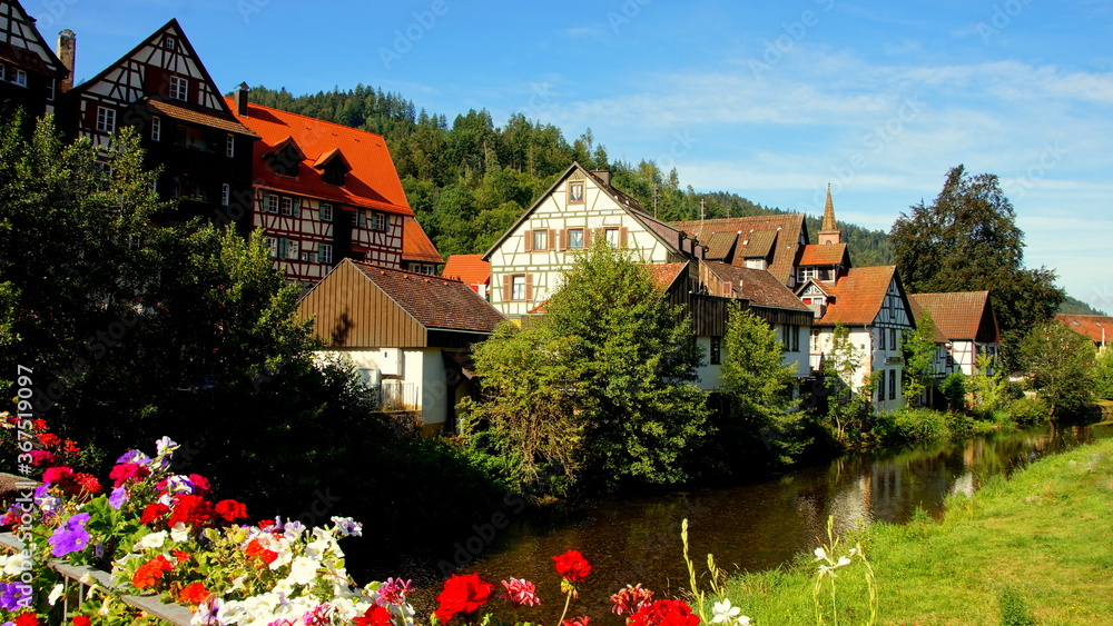 herrlicher Blick von Brücke mit Blumen auf Schiltach am Fluss Kinzig im Schwarzwald an sonnigem Tag herrlicher Blick von Brücke mit Blumen auf Schiltach am Fluss Kinzig im Schwarzwald an sonnigem Tag