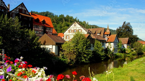 herrlicher Blick von Brücke mit Blumen auf Schiltach am Fluss Kinzig im Schwarzwald an sonnigem Tag photo