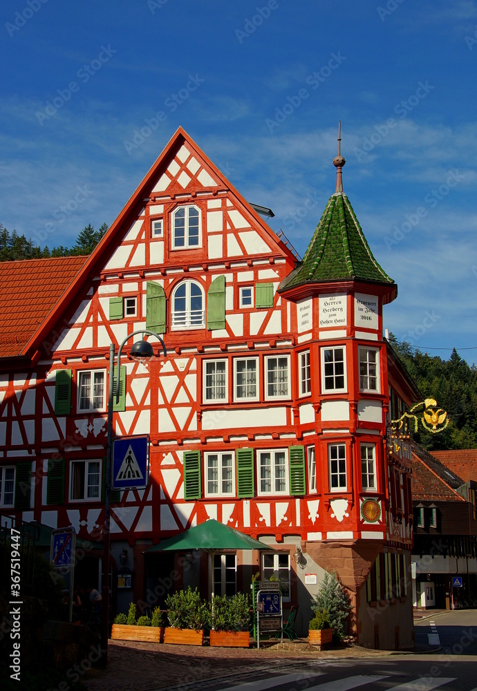 Naklejka premium dekoratives Fachwerkhaus mit Turm in Schiltach im Schwarzwald unter blauem Himmel