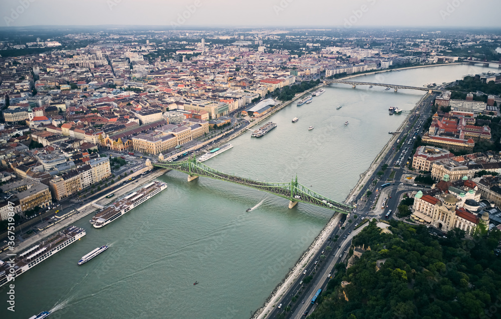 Aerial view of the Liberty Bridge by Danube river in Budapest, Hungary. Gathered people during summer evening. The Freedom Bridge is closed for motorised vehicles and open for pedestrians only.
