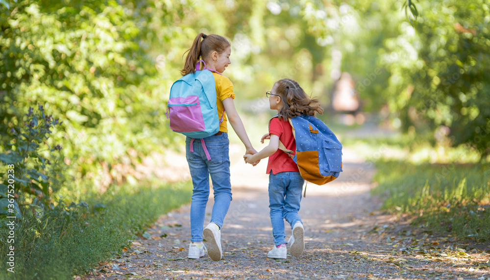 Fototapeta premium Girls with backpack are going to school