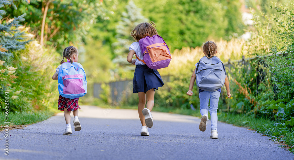 Fototapeta premium Girls with backpack are going to school