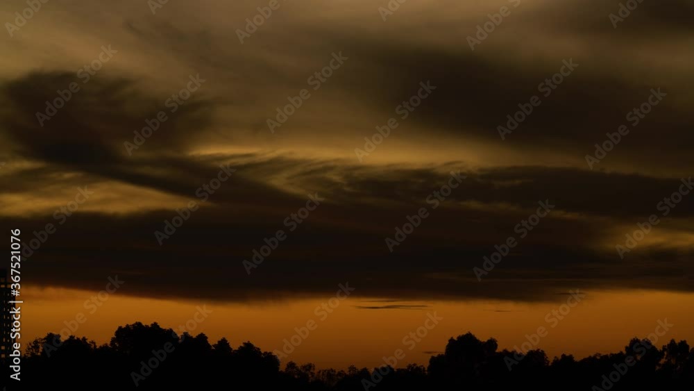 The fiery moon rising in the night sky over the landscape - time lapse The fiery moon rising in the night sky over the landscape - time lapse