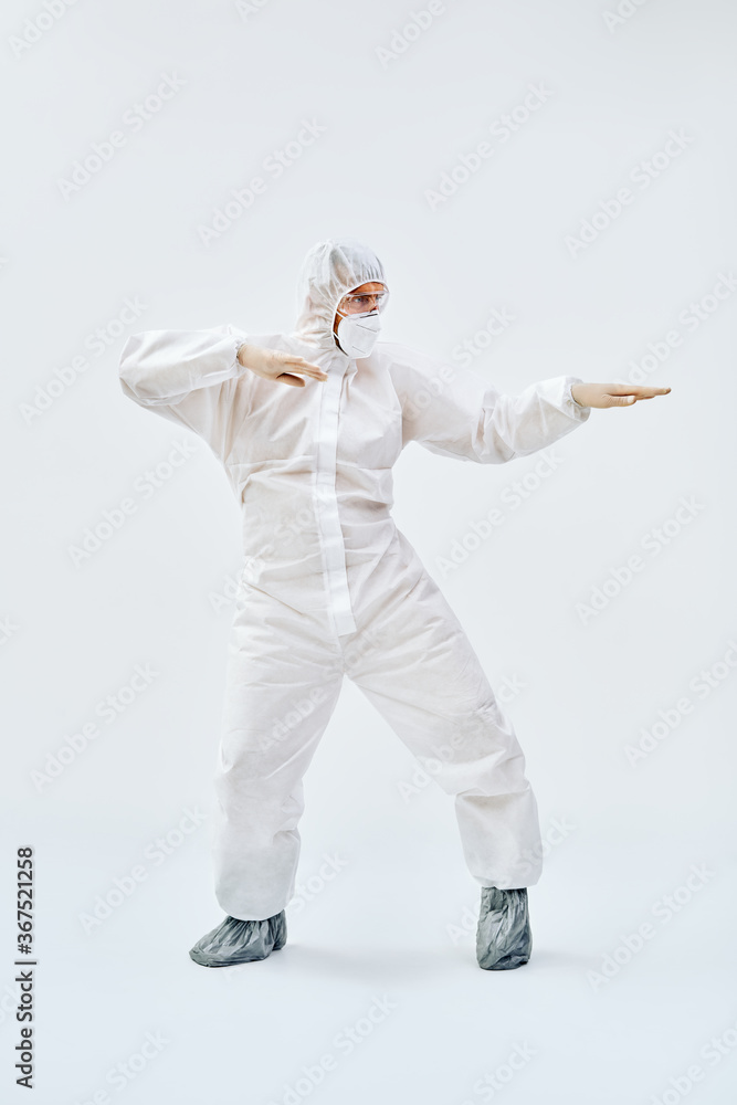 Full lenght portrait of happy dancing doctor in PPE suit on blue background Full lenght portrait of happy dancing doctor in PPE suit on blue background