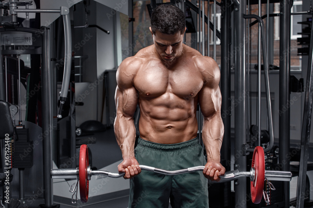 Fototapeta premium Muscular man working out in gym. Strong male naked torso abs