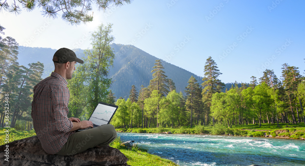 Obraz premium man working remotely outdoors with laptop