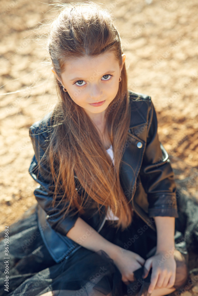 Naklejka premium Children's fashion. Fashionable child. Girl outdoors in fashionable clothes. High quality photo.