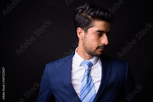Young handsome bearded Persian businessman against black background © Ranta Images