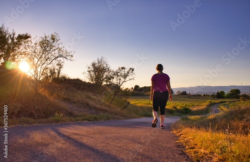 Running, jogging sur une route le soir au coucher du soleil avec la montagne en face