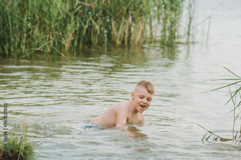 Fototapeta premium Happy boy swimmimg in the lake . Summer Holidays