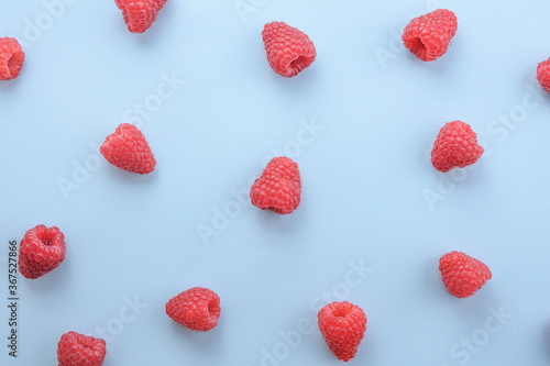 Pattern of raspberry on blue background. Flat lay summer berries - red raspberries. Creative minimalism
