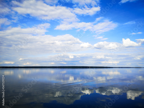 Clouds on a blue sky with reflection in water