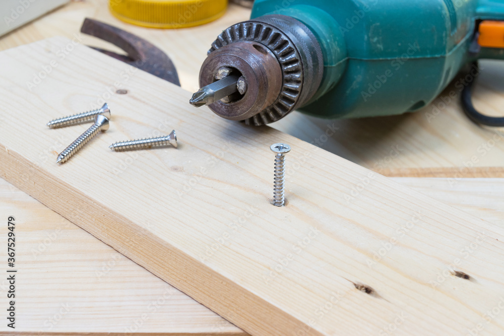 Electric drill with nut on wood too for construction craft Electric drill with nut on wood too for construction craft