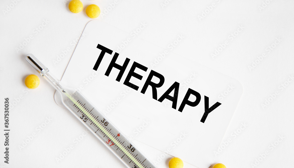 Obraz premium On the card is the inscription THERAPY, next to the thermometer and yellow tablets.