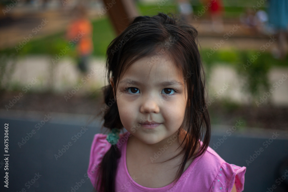 Portrait of a little girl. Asian girl on the street.