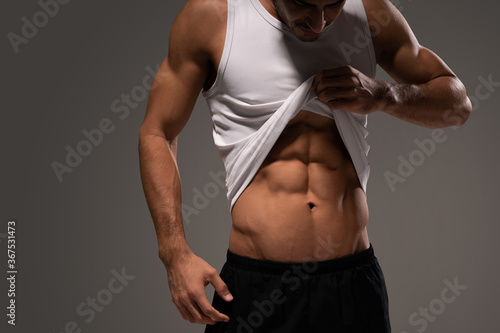 Tableau sur toile Male Athlete Looking At His Six Packs