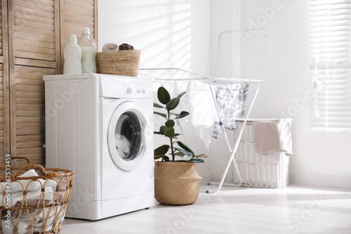 Fototapeta Modern washing machine in laundry room interior