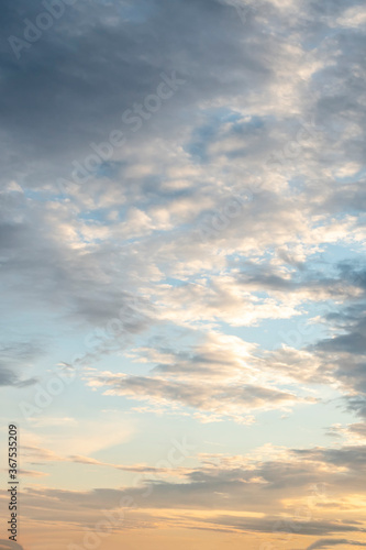 sun sets behind the clouds in the blue evening sky as a natural background © westermak15
