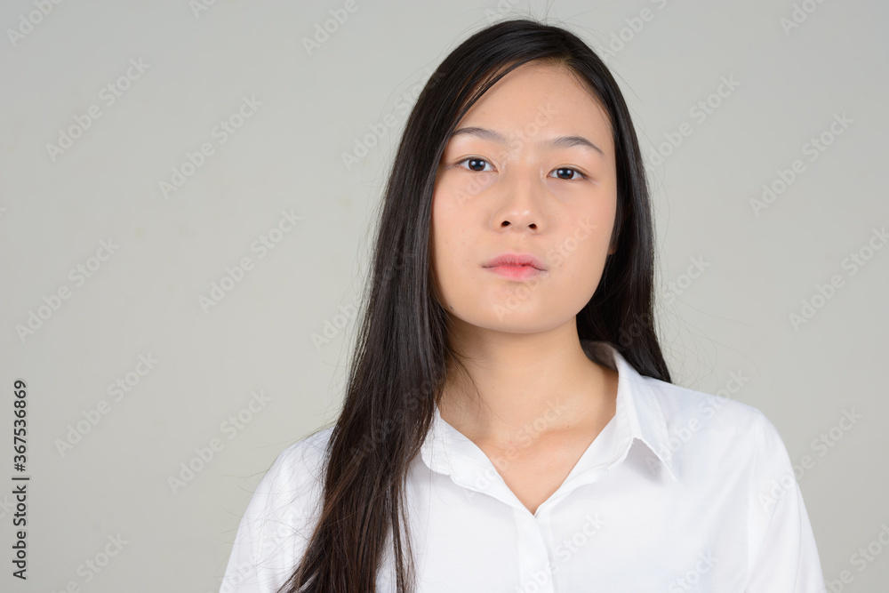Portrait of young beautiful Asian businesswoman against white background Portrait of young beautiful Asian businesswoman against white background