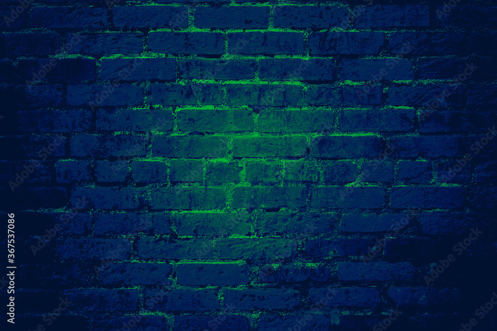 Blue brick wall background texture with glowing green light shining through cracks