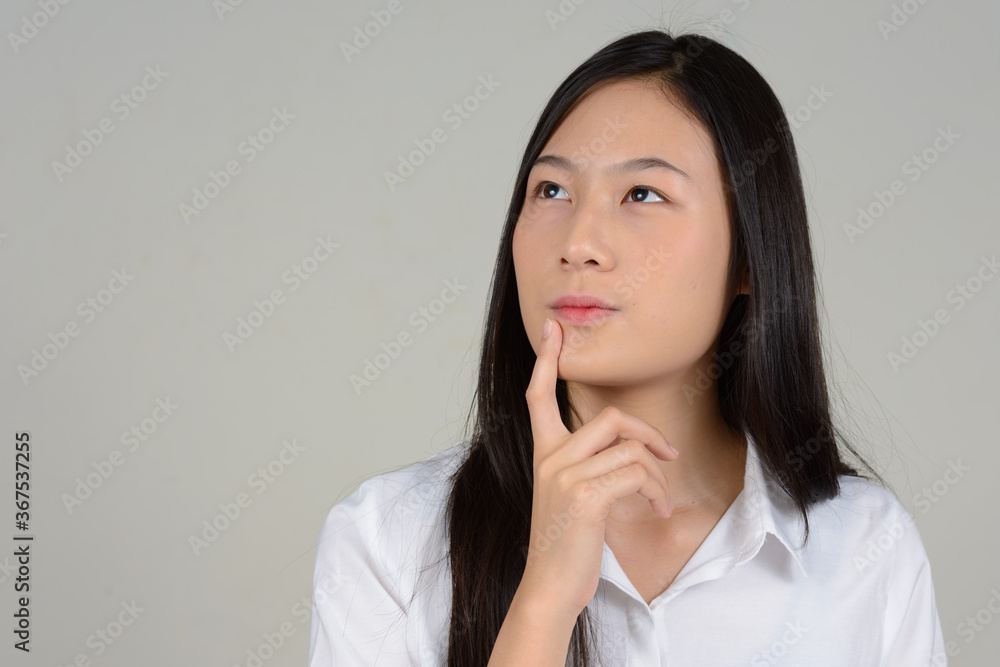 Portrait of young beautiful Asian businesswoman against white background Portrait of young beautiful Asian businesswoman against white background