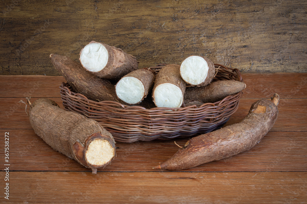 Fresh Cassava root on a wooden background. Copy space.