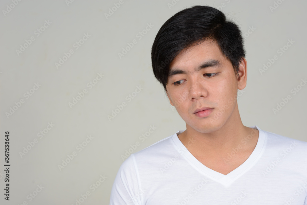 Portrait of young handsome Asian man against white background Portrait of young handsome Asian man against white background