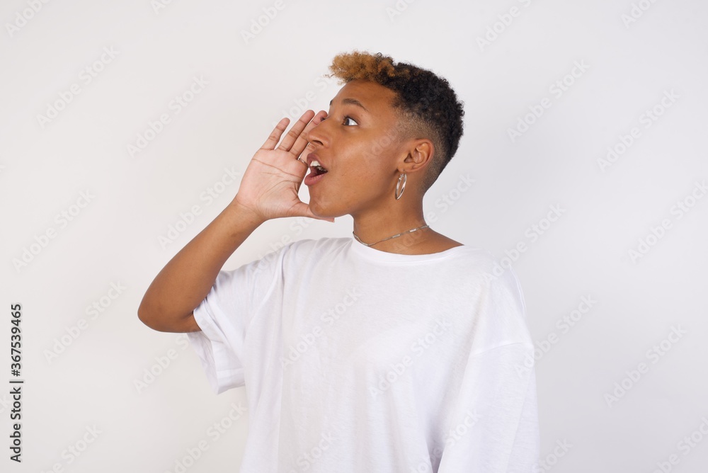 young Caucasian woman, standing against yellow background profile view, looking happy and excited, shouting and calling to copy space. young Caucasian woman, standing against yellow background profile view, looking happy and excited, shouting and calling to copy space.