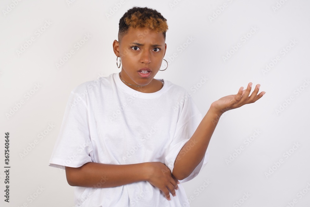 What the hell are you talking about, nonsense. Studio shot of frustrated female with blonde hair gesturing with raised palm, frowning, being displeased and confused with dumb question over gray wall. What the hell are you talking about, nonsense. Studio shot of frustrated female with blonde hair gesturing with raised palm, frowning, being displeased and confused with dumb question over gray wall.