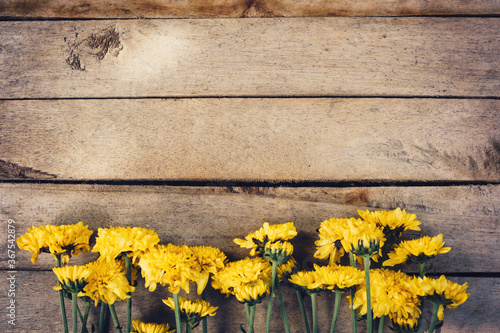 Yellow flowers of bouquet, top view on wooden background texture with copy space