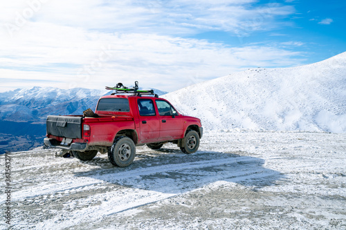 Red pickup truck on road, Beautiful winter road under snow mountains New Zealand.