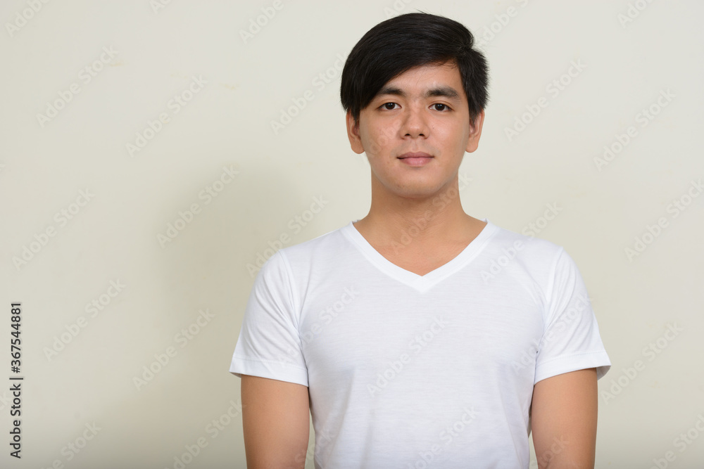 Portrait of young handsome Asian man against white background Portrait of young handsome Asian man against white background