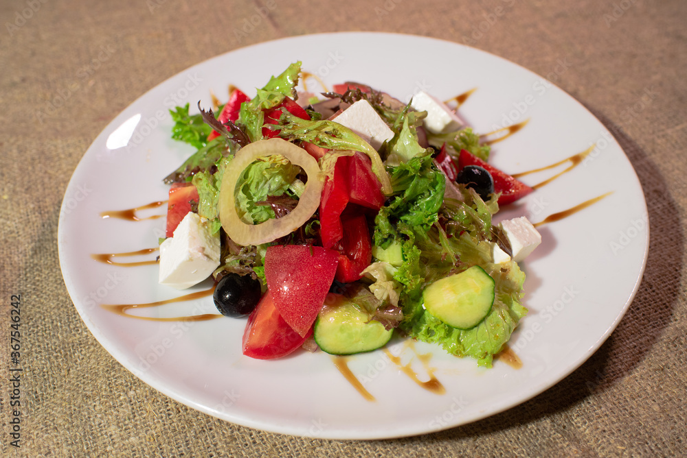 Delicious and healthy Greek salad on a white plate Delicious and healthy Greek salad on a white plate