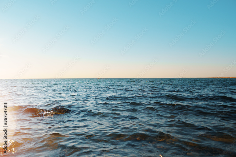 Naklejka premium Dark blue sea waves on the sunset